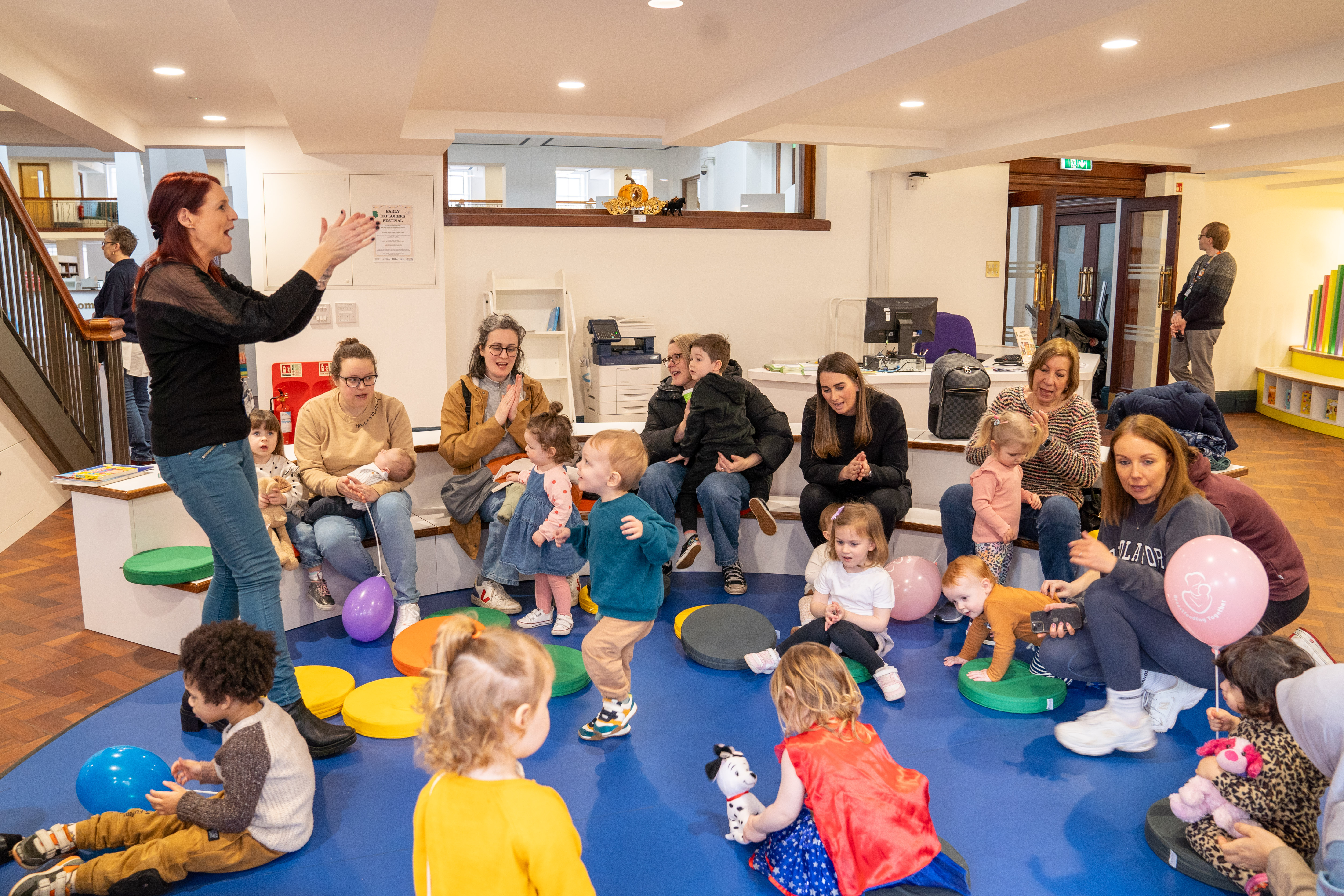 This is a photo of Toddler Tales taking place. The children are sat in a circle listening to an interactive story.