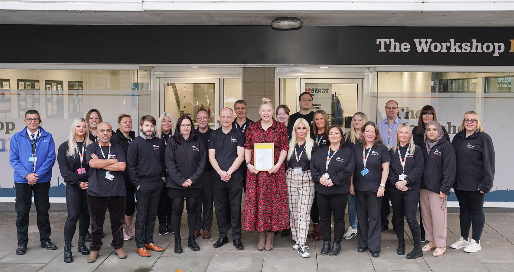 Photograph of the entire workshop staff grouped together outside the office.